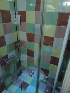 a bathroom with a shower with colorful tiles at Room "frog" in a neoclasical house in Kastoria