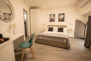 a bedroom with a bed and a chair and a mirror at C'era una volta in Assisi