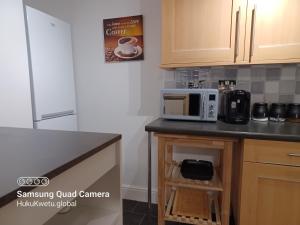 a kitchen with a counter with a microwave on it at Huku Kwetu -The Maltings- Black Door-1st Floor-2 Bedroom Apartment -Self Catering-Quiet- Free Parking in Dunstable