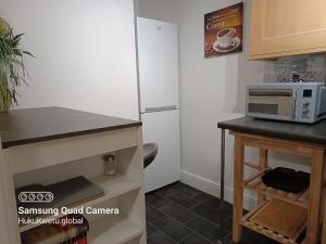 a kitchen with a white refrigerator and a microwave at Huku Kwetu -The Maltings- Black Door-1st Floor-2 Bedroom Apartment -Self Catering-Quiet- Free Parking in Dunstable