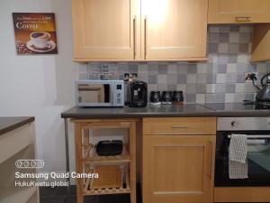 a kitchen with a counter top with a microwave at Huku Kwetu -The Maltings- Black Door-1st Floor-2 Bedroom Apartment -Self Catering-Quiet- Free Parking in Dunstable