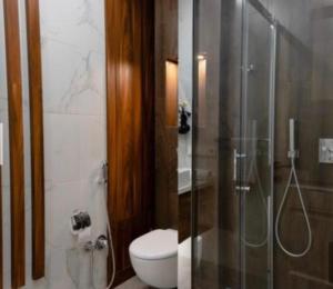 a bathroom with a toilet and a glass shower at king david residence apartment tbilisi in Tbilisi City +25 photos