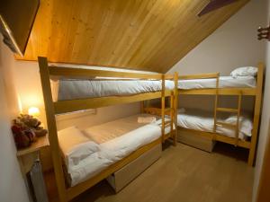 2 literas en una habitación con techo de madera en Duplex 3 dormitorios en plaza de Andalucía, en Sierra Nevada