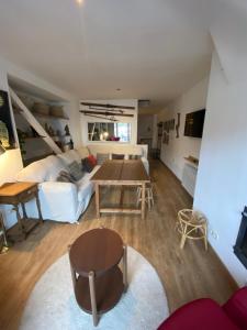 Una sala de estar con un sofá blanco y una mesa. en Duplex 3 dormitorios en plaza de Andalucía, en Sierra Nevada