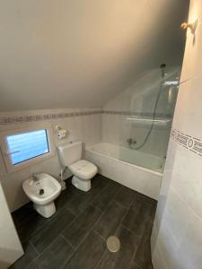 Un baño con inodoro, bañera y lavabo. en Duplex 3 dormitorios en plaza de Andalucía, en Sierra Nevada 9 fotos más