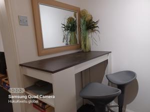 a mirror sitting on top of a fireplace with a stool at Huku Kwetu -The Maltings- Black Door-1st Floor-2 Bedroom Apartment -Self Catering-Quiet- Free Parking in Dunstable