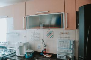 a kitchen with a sink and a microwave at Apartamento Rio das Ostras, Extensão do Bosque in Rio das Ostras