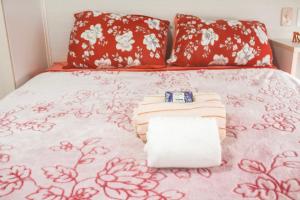 Una cama con toallas y almohadas. en Apartamento Rio das Ostras, Extensão do Bosque, en Rio das Ostras