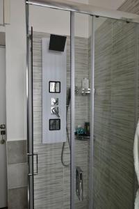 una doccia con porta in vetro in bagno di Casa Capolino a Scauri