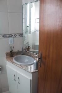 uma casa de banho com um lavatório e um espelho em Apartamento Rio das Ostras, Extensão do Bosque em Rio das Ostras