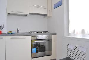 a kitchen with a stainless steel stove and white cabinets at Lombardi Abbeveratoia in Parma +9 photos