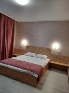 a bedroom with a large bed with two pillows at PerfectHotel in Myrhorod