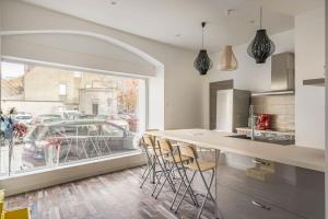 cocina con encimera con sillas y ventana en Superbe appartement avec parking gratuit en Lons-le-Saunier