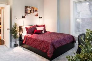 a bedroom with a bed with a red comforter at Gorgeous 1BR Wooster Sq. apt. - wshr/dryr, parking in New Haven