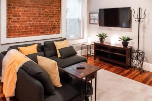 a living room with a couch and a tv at Gorgeous 1BR Wooster Sq. apt. - wshr/dryr, parking in New Haven