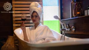 a woman sitting in a bath tub holding a glass of wine at Chiang Mai Las Orquideas Resort in Chiang Mai +198 photos