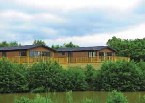 a large wooden house with a large deck at Kingswood Golf Lodges in Thorne