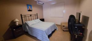 a bedroom with a bed and a dresser and a fan at Dúplex amplio y luminoso in San Fernando del Valle de Catamarca