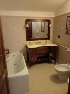 a bathroom with a tub and a sink and a toilet at Country-House vista montagna in Foce