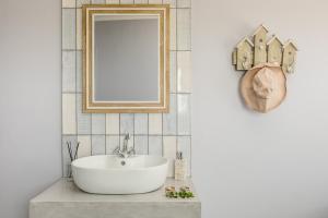 a bathroom with a white sink and a mirror at Turtle n Tides in St Helena Bay +36 photos
