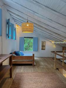 Großes Zimmer mit einem Bett und einem Fenster in der Unterkunft Casinha do Rio in Caraíva
