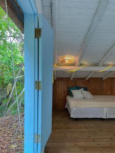 ein Schlafzimmer mit einem Bett in einem Holzhaus in der Unterkunft Casinha do Rio in Caraíva