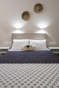 a bedroom with a bed with a blue eye on it at Dilion Hotel in Parikia