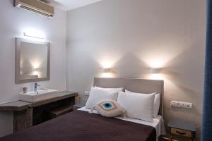 1 dormitorio con cama con lavabo y espejo en Dilion Hotel en Parikia