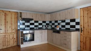 eine Küche mit schwarz-weißen karierten Wandfliesen in der Unterkunft Chachata - Jeseníky - polosamota in Dolní Moravice