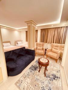 een woonkamer met een bank en een bed bij El mansour hotel apartmen 94 in Mansoura