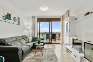 ein Wohnzimmer mit einem Sofa und einem TV in der Unterkunft CB Living - Modern apartment, Terrazas de Campoamor in Orihuela