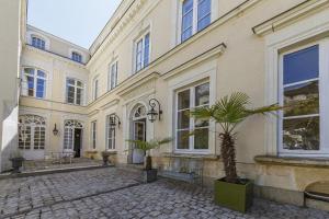 a large building with a palm tree in the courtyard at Maison Bossoreil - appartement Aubance in Angers