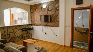 uma sala de estar com um sofá e uma televisão na parede em Dobricin Konak Apartments em Kopaonik