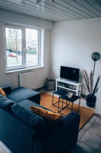 a living room with a couch and a tv at Vakantieappartement DE SPUIKOM in Ostend