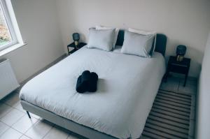 a bedroom with a bed with a black hat on it at Vakantieappartement DE SPUIKOM in Ostend