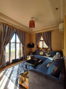 uma sala de estar com um sofá e uma mesa em ApartHotel Nzaha em Tahannout