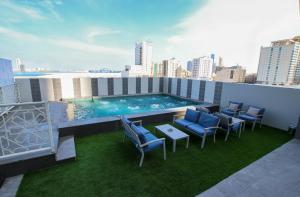 a rooftop patio with a swimming pool on a building at The Seven Hotel in Manama