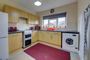 a kitchen with a washing machine and a washer at Hagrid's Hut in Watford