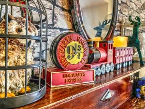 a toy train sitting on a shelf next to a mirror at Hagrid's Hut in Watford