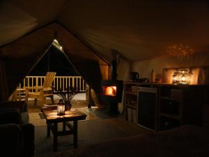 Camera con tenda, tavolo e piano cottura. di Mežurgu teltis a Dikļi