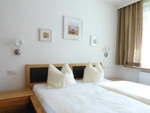 1 Schlafzimmer mit 2 Betten und weißen Kissen in der Unterkunft Sagmeister Loft in Jenig
