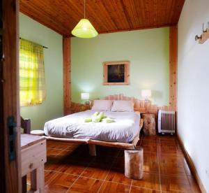 ein Schlafzimmer mit einem großen Bett in einem Zimmer in der Unterkunft A Barraka: your cozy house in Flores! in Lajes das Flores