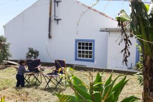ein Kind steht in einem Hof vor einem Haus in der Unterkunft A Barraka: your cozy house in Flores! in Lajes das Flores