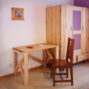 einen Holzschreibtisch mit einem Stuhl und einem Schrank in der Unterkunft A Barraka: your cozy house in Flores! in Lajes das Flores
