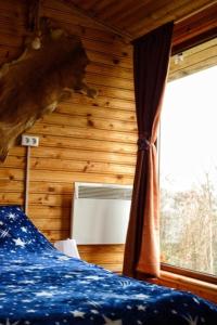 1 dormitorio con 1 cama y ventana con aire acondicionado en Catunu’ lui Emil en Cărbuneşti