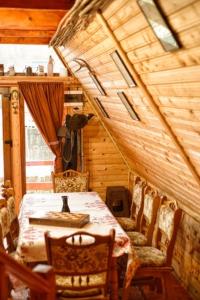 comedor con mesa y sillas en una cabaña en Catunu’ lui Emil en Cărbuneşti