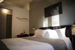 una camera da letto con un grande letto con cuscini bianchi di Mich&Letti a Brescia