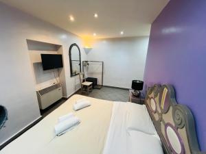 a bedroom with a large white bed with purple walls at Appartamento Mellini in Rome