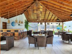 a restaurant with tables and chairs and a bar at Armonia De Las Terrenas Gorgeous Penthouse in Las Terrenas