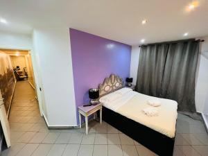 a bedroom with a bed and a purple wall at Appartamento Mellini in Rome